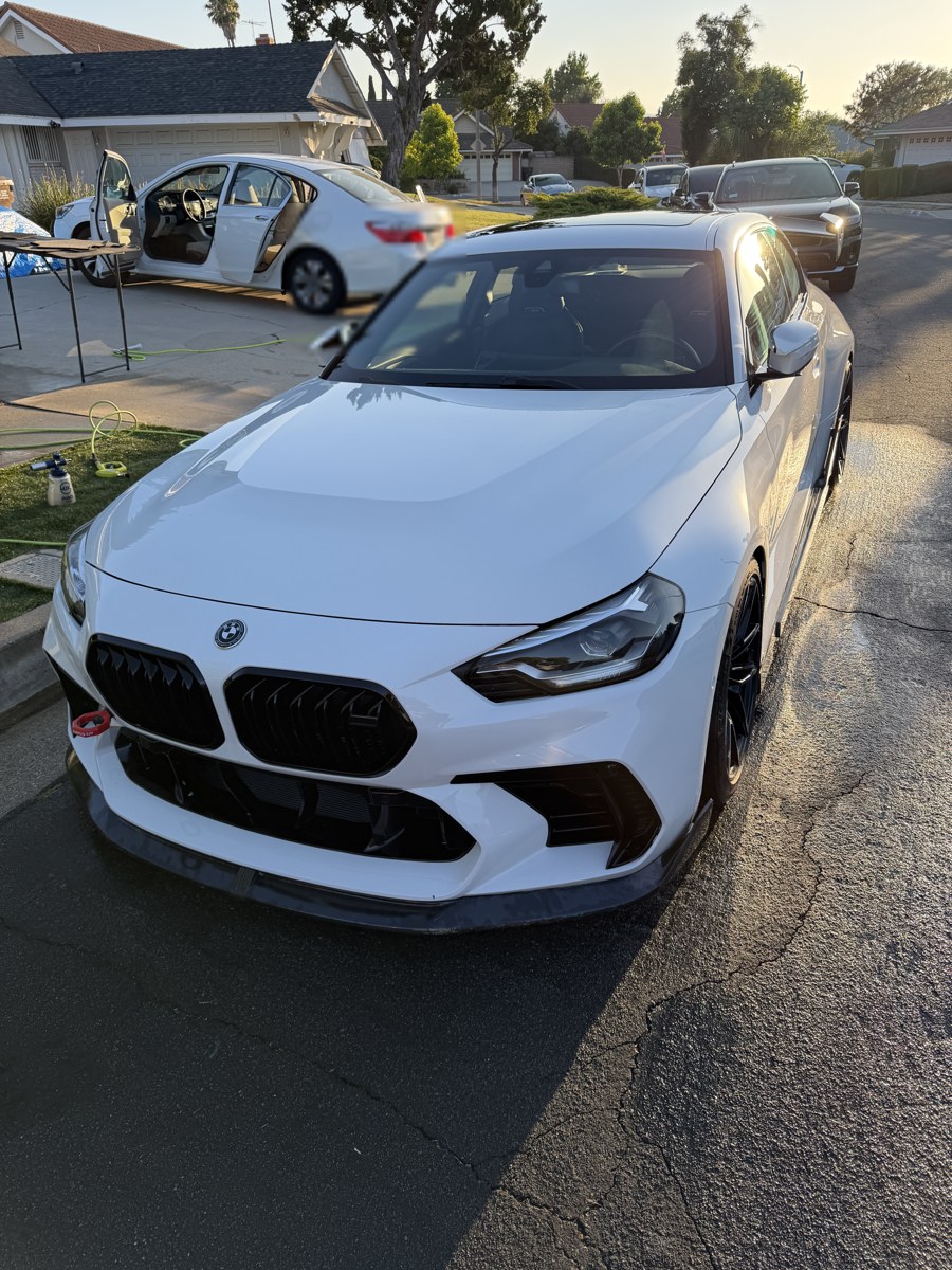 White BMW M2 detailed to a deep gloss in a driveway