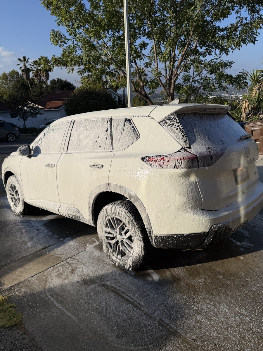 SUV covered in snow foam during a wash